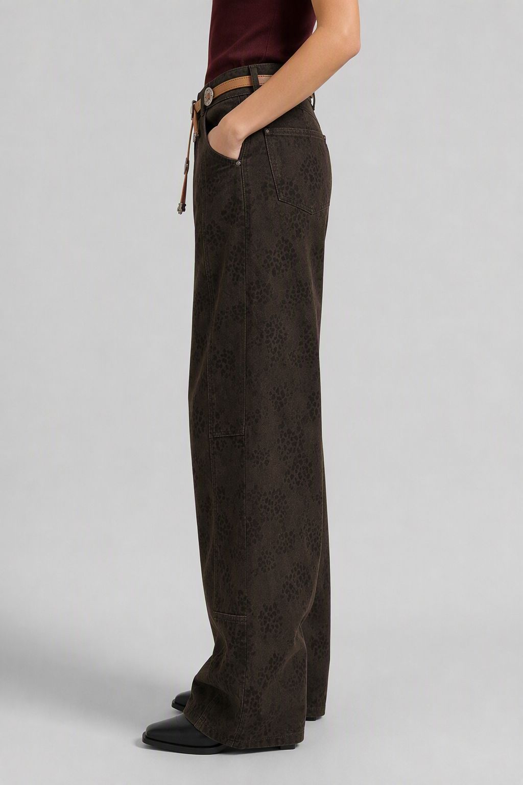 Side view of QAYQEY dark-brown banana-leg jeans showing the curved silhouette and long inseam