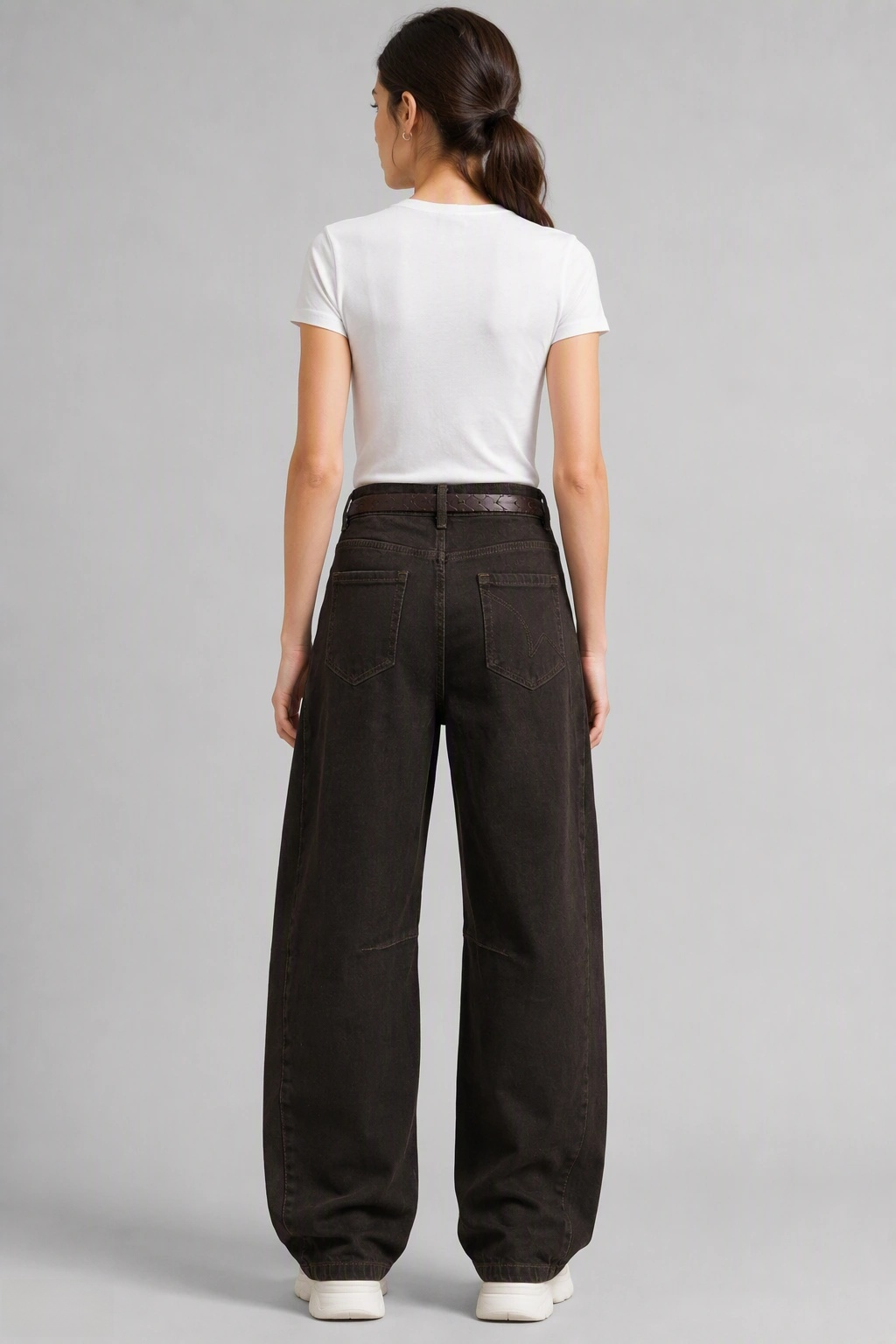 Back view of QAYQEY dark-brown curved-leg jeans, waist-down crop on model