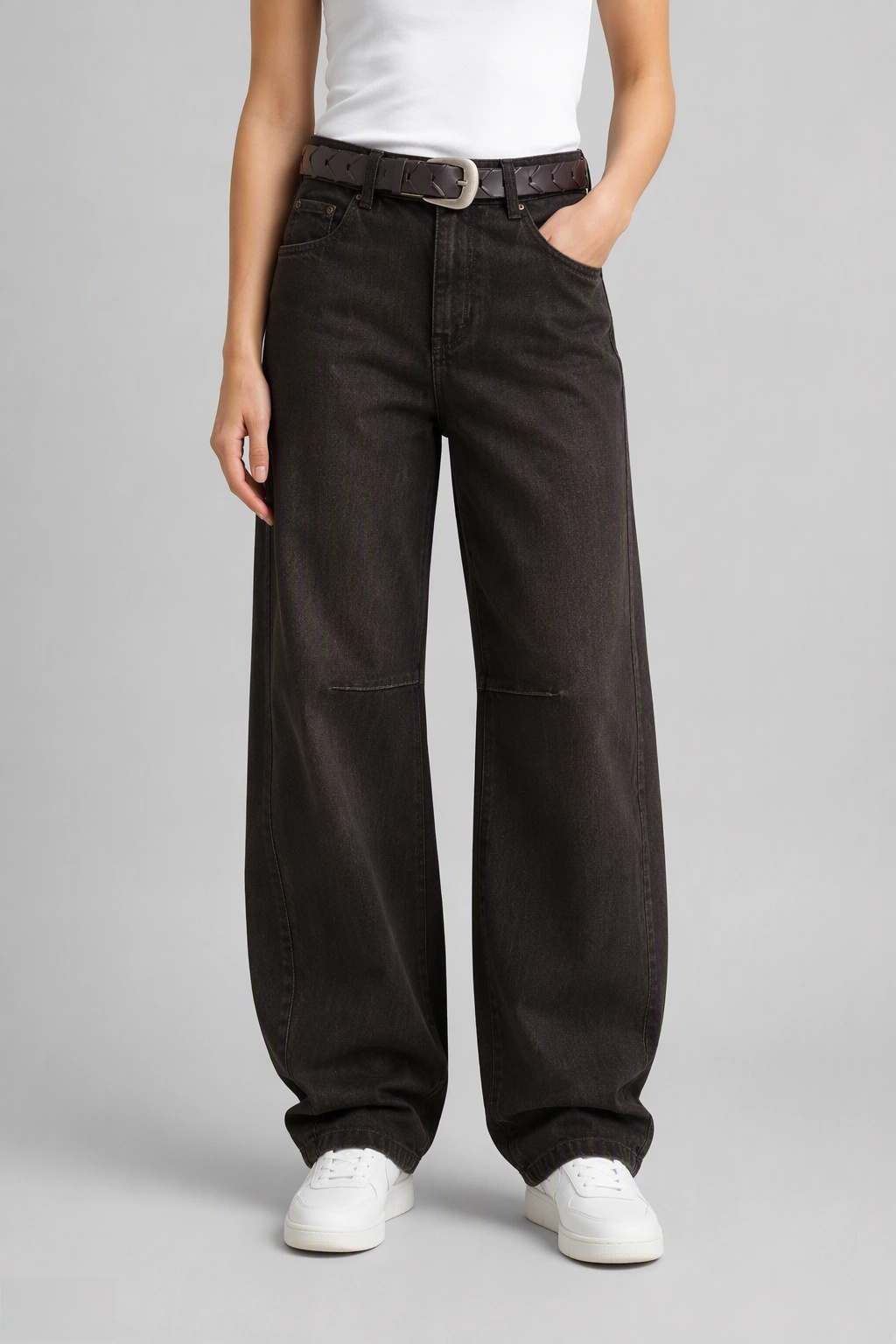 Front view of QAYQEY dark-brown curved-leg jeans, waist-down crop on model