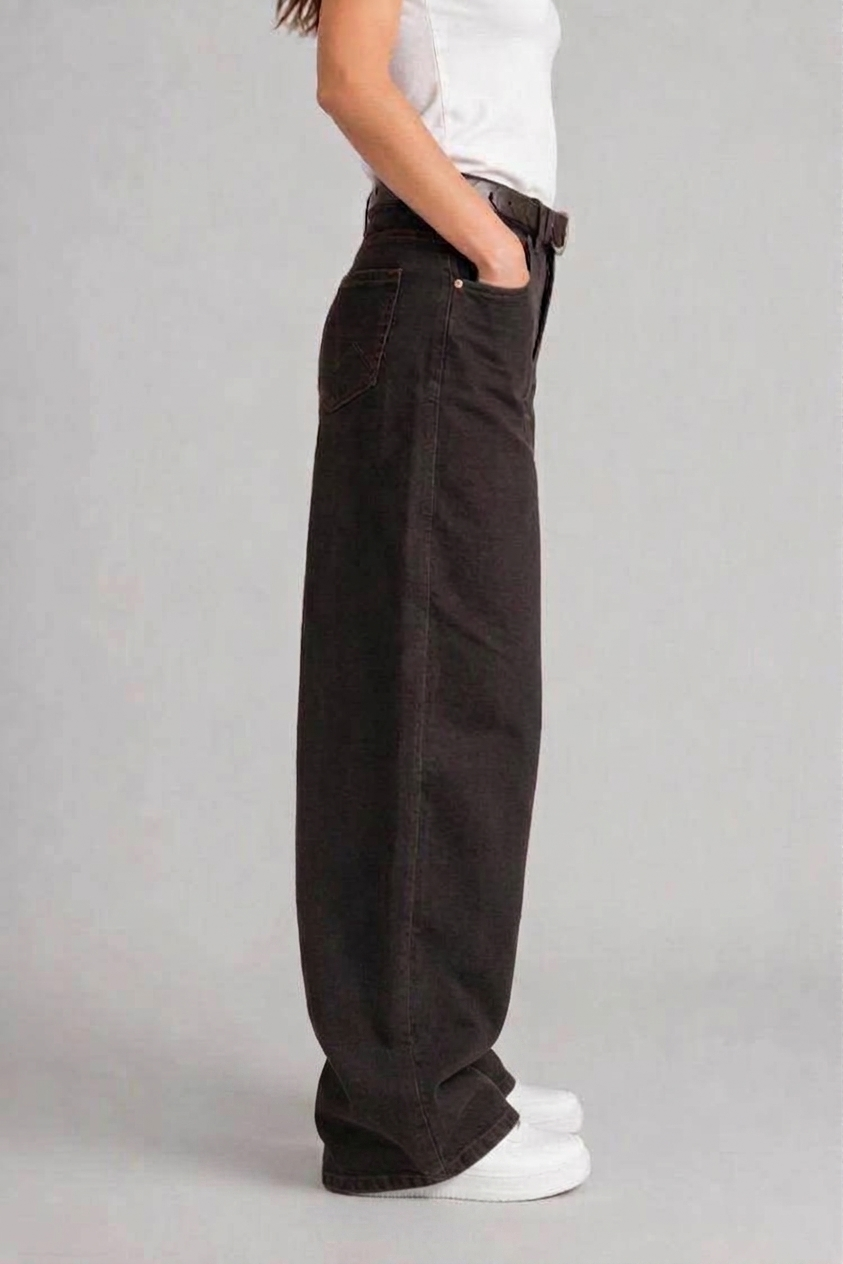 Side view of QAYQEY dark-brown curved-leg jeans, showing the curved outseam