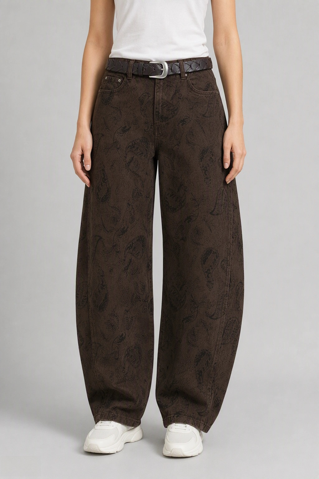 Front view of QAYQEY brown paisley-jacquard curved-leg jeans, waist-down crop on model