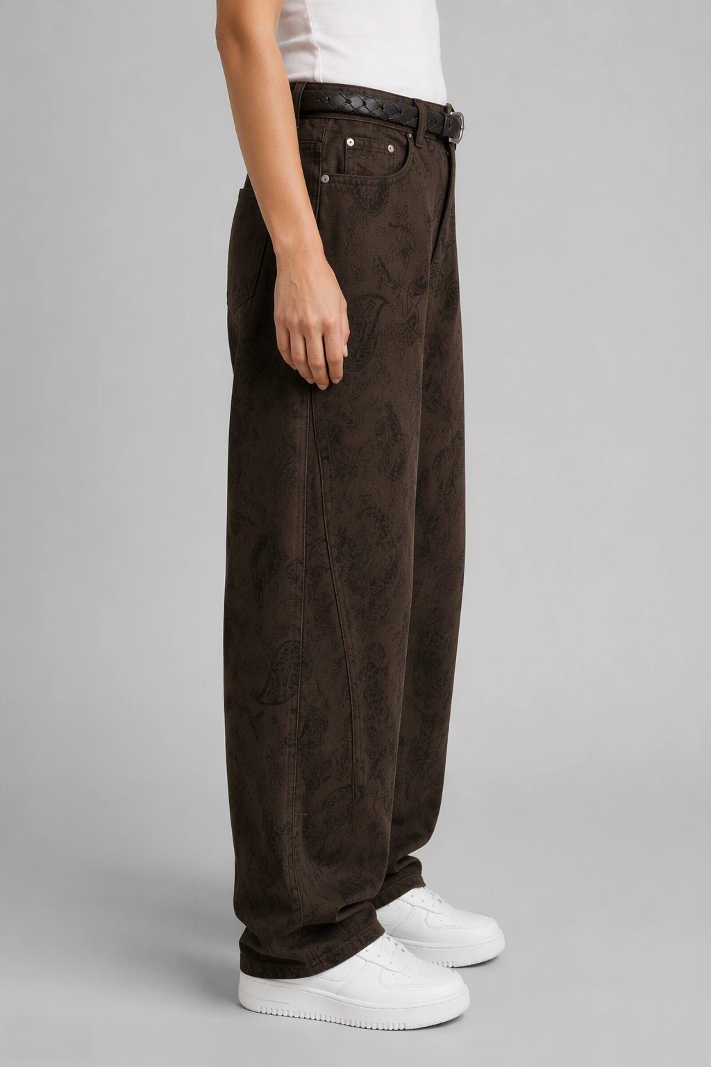 Side view of QAYQEY brown paisley-jacquard curved-leg jeans, showing the curved outseam