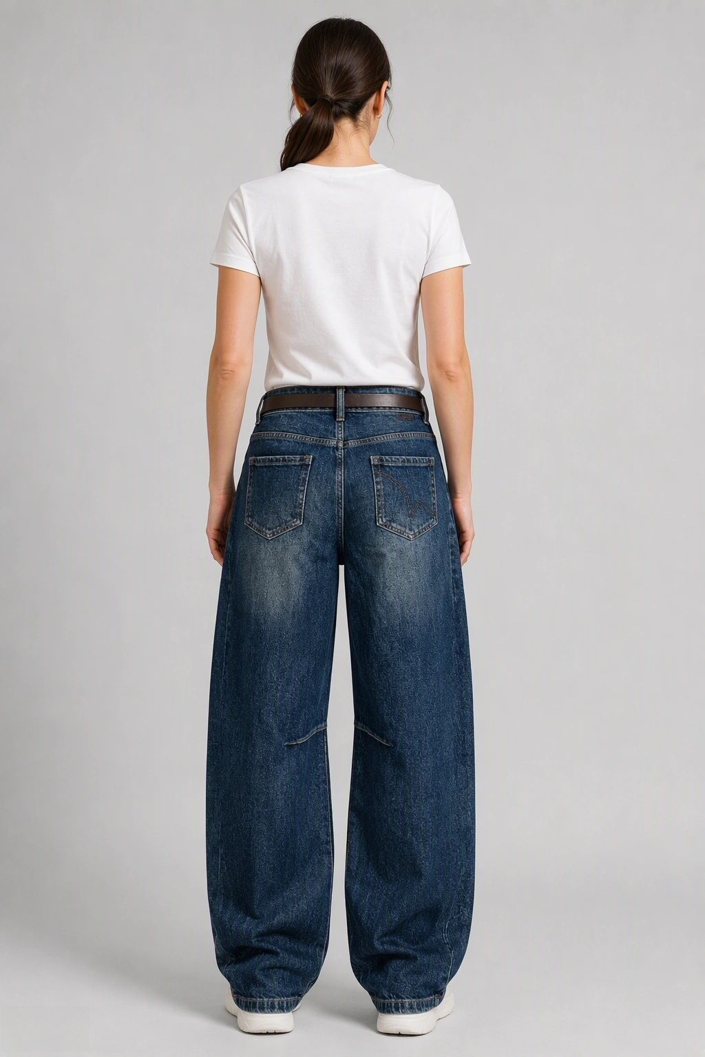 Back view of QAYQEY deep-blue knee-dart curved-leg jeans, waist-down crop on model