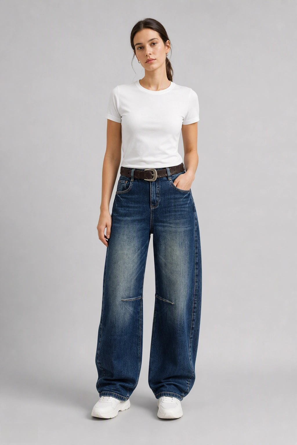 Full-body view of model wearing QAYQEY deep-blue knee-dart curved-leg jeans with a white tee and white sneakers