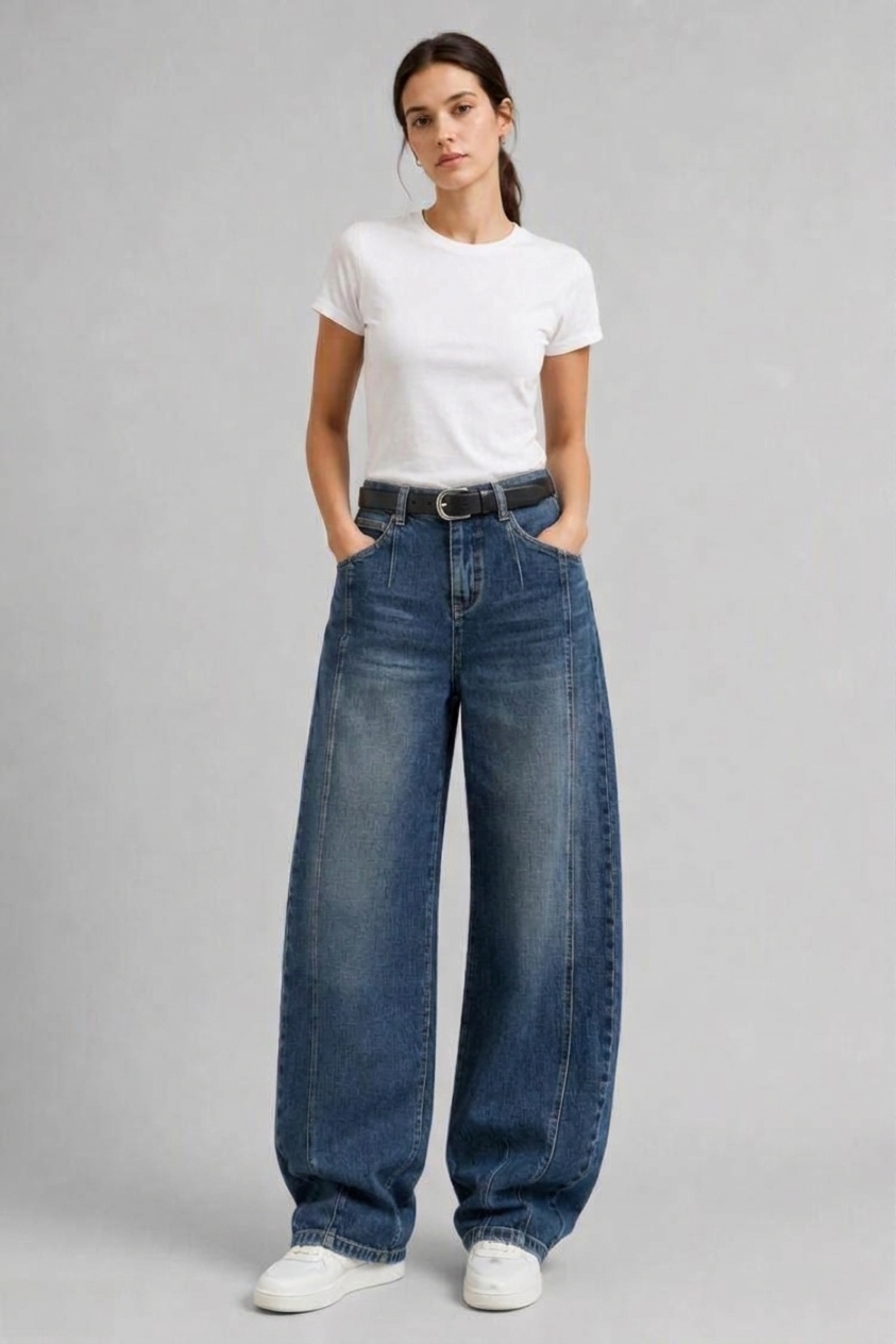 Full-body view of model wearing QAYQEY vintage-blue curved-leg jeans with a white tee and white sneakers