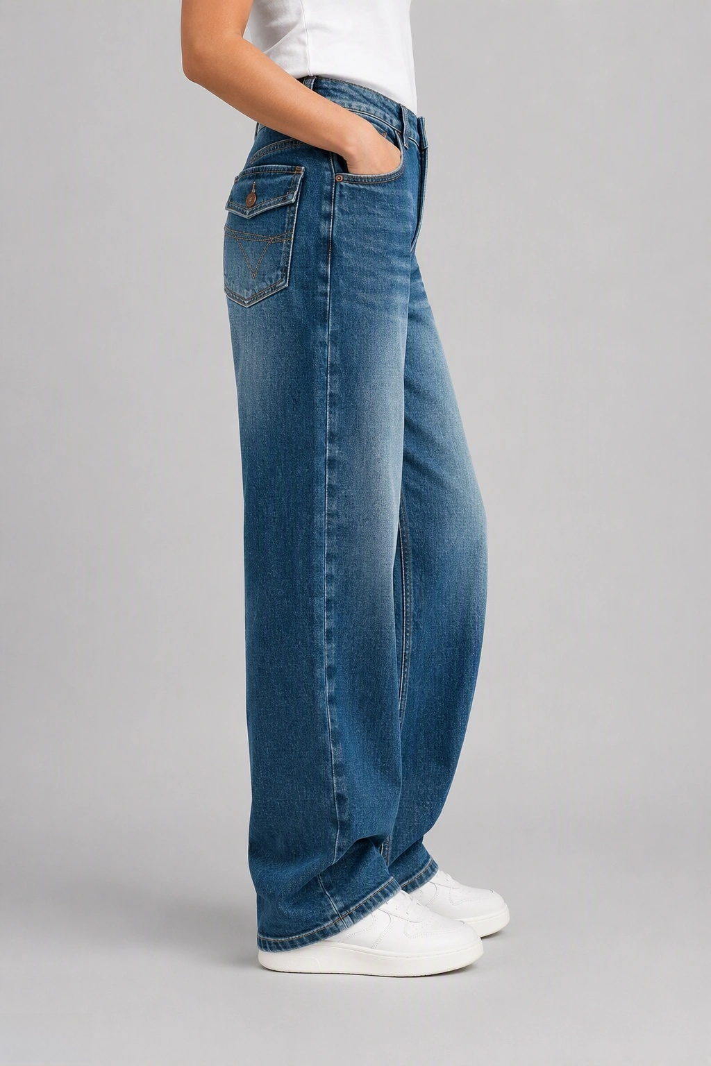 Side view of QAYQEY mid-blue flap-pocket curved-leg jeans, showing the curved outseam