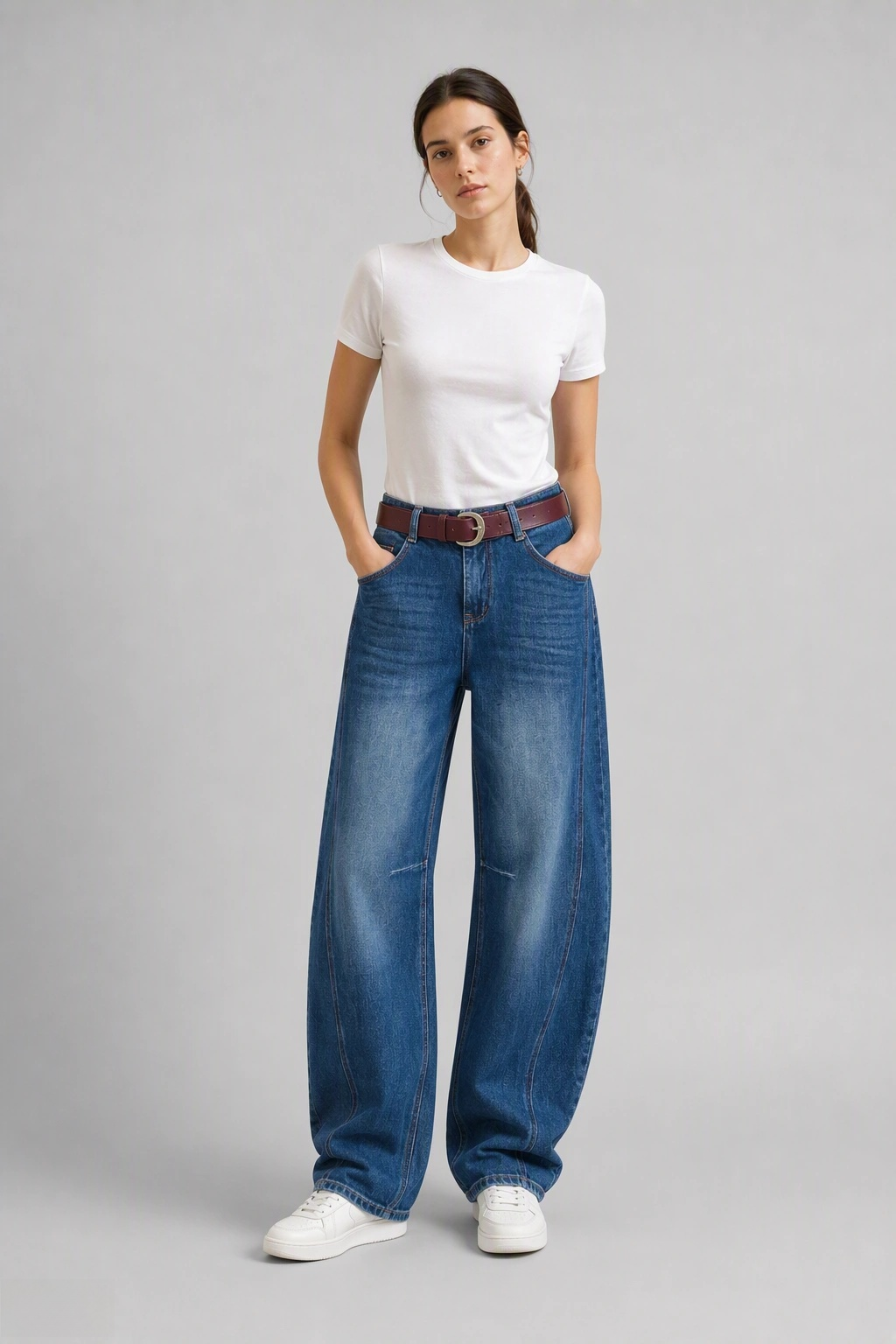 Full-body view of model wearing QAYQEY light-blue faded curved-leg jeans with a white tee and white sneakers