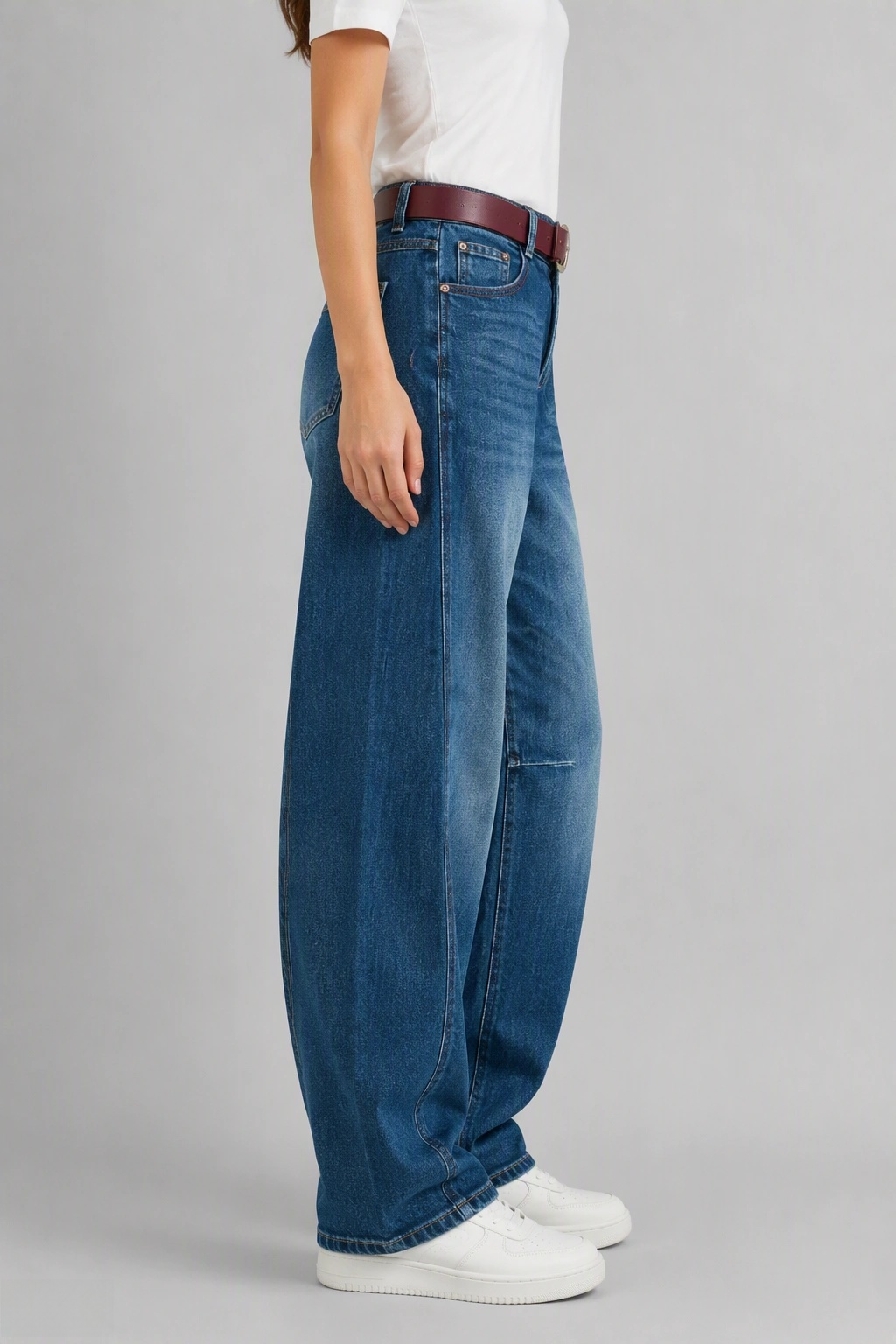 Side view of QAYQEY light-blue faded curved-leg jeans, showing the curved outseam