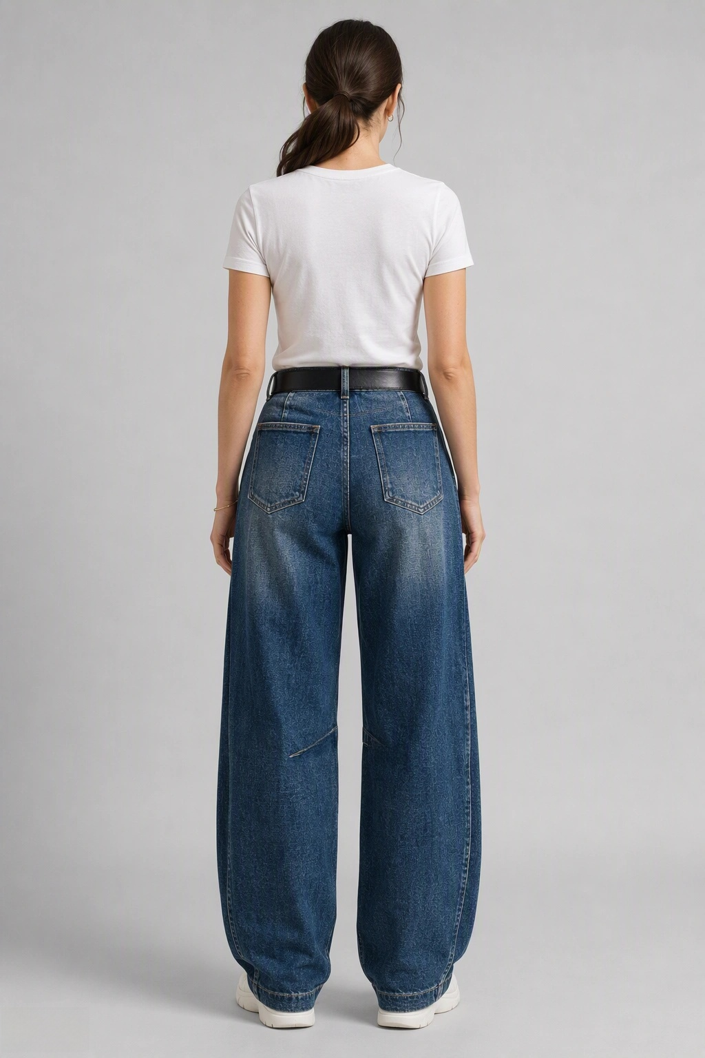Back view of QAYQEY dark-blue knee-seam curved-leg jeans, waist-down crop on model