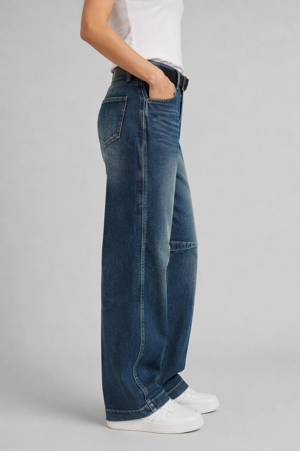 Side view of QAYQEY dark-blue knee-seam curved-leg jeans, showing the curved outseam