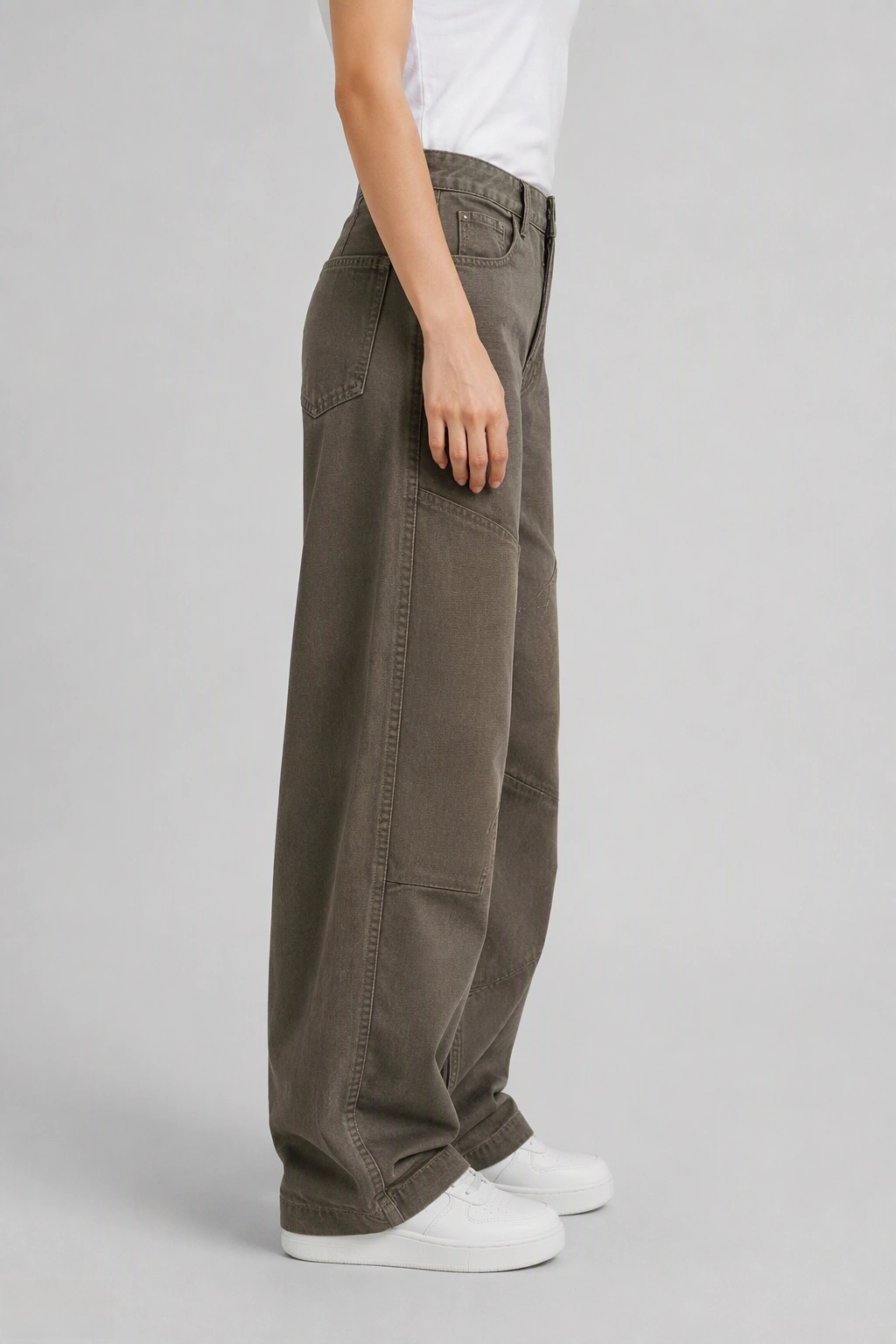 Side view of QAYQEY olive-green curved-leg jeans, showing the curved outseam