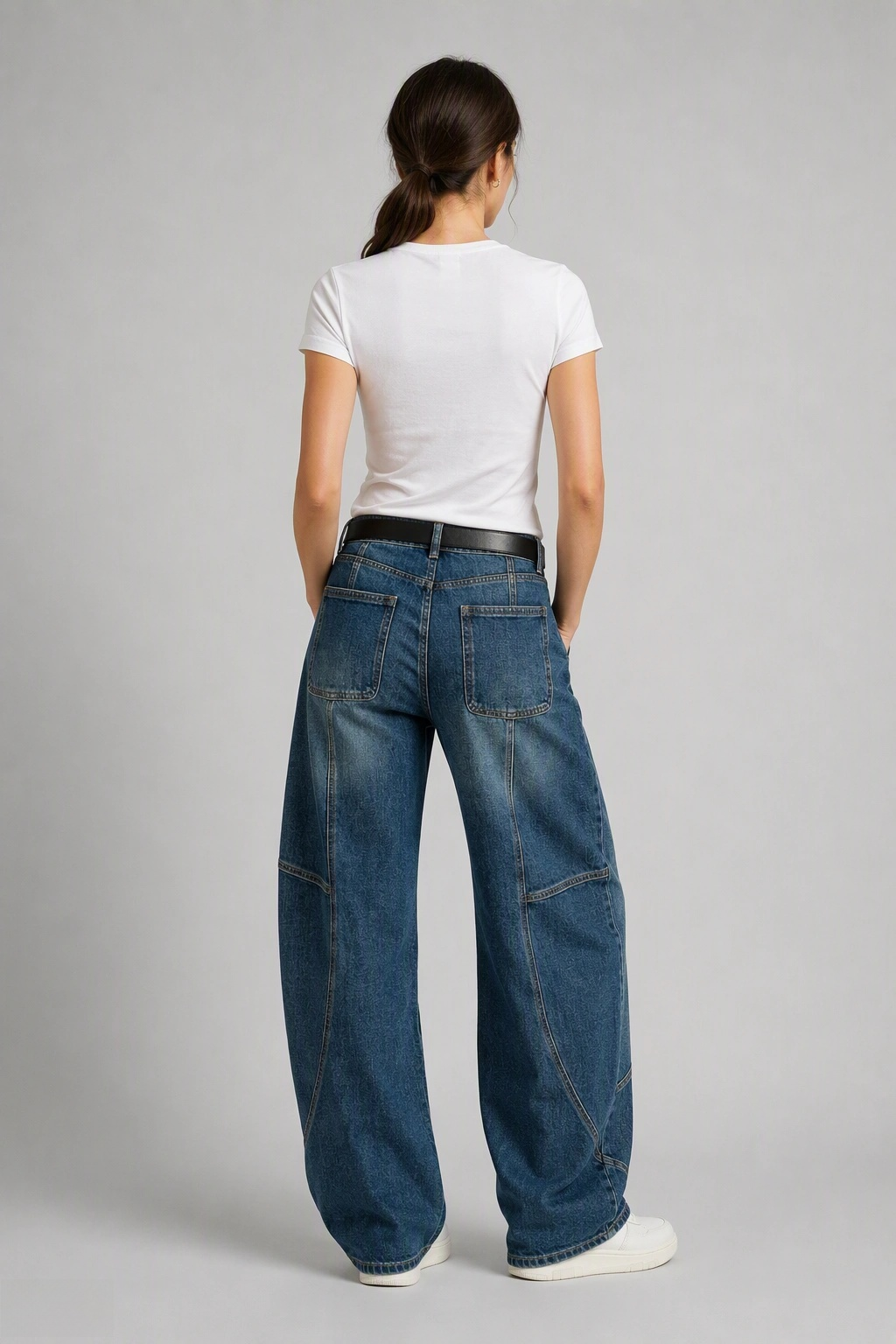 Back view of QAYQEY mid-blue washed curved-leg jeans, waist-down crop on model