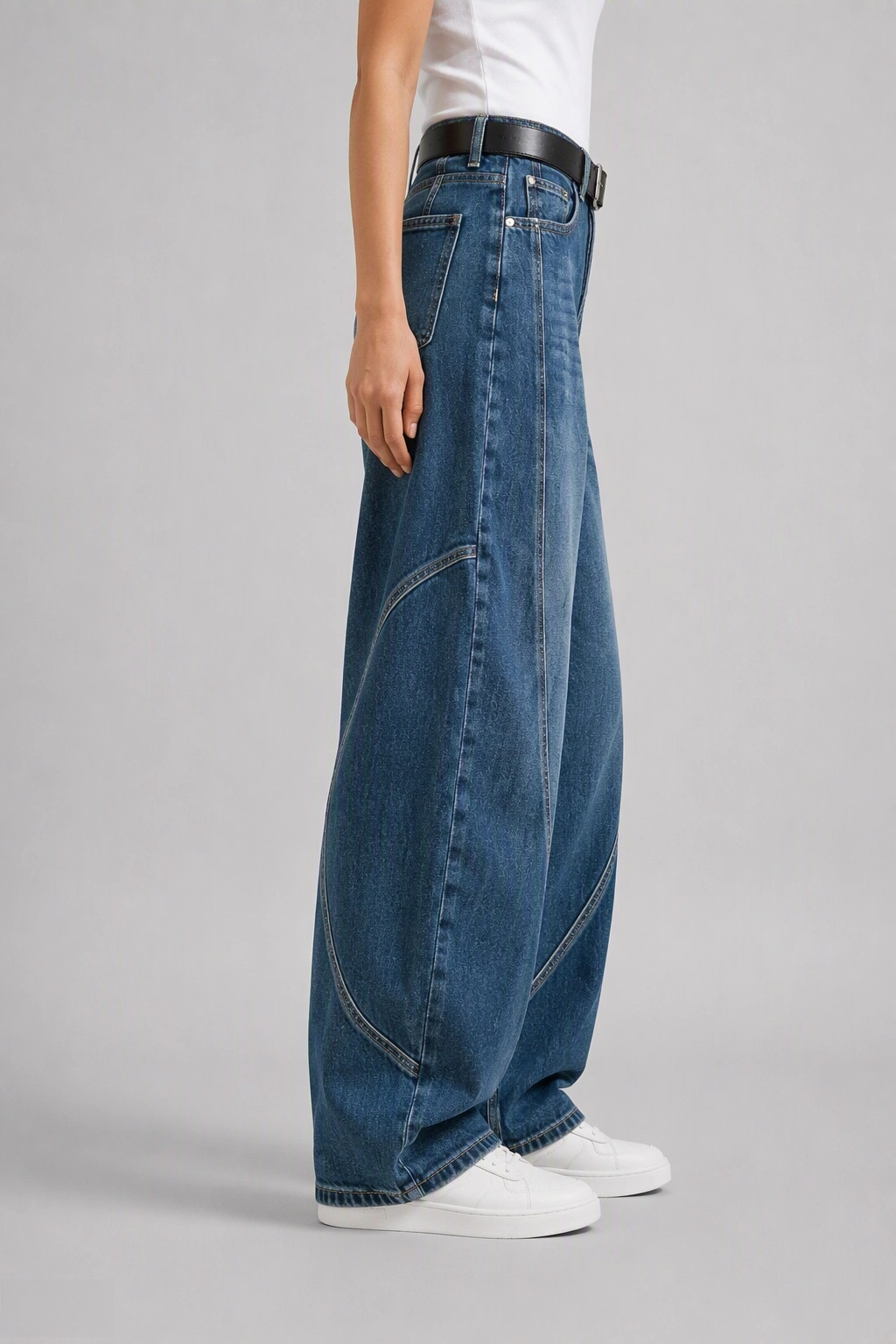 Side view of QAYQEY mid-blue washed curved-leg jeans, showing the curved outseam