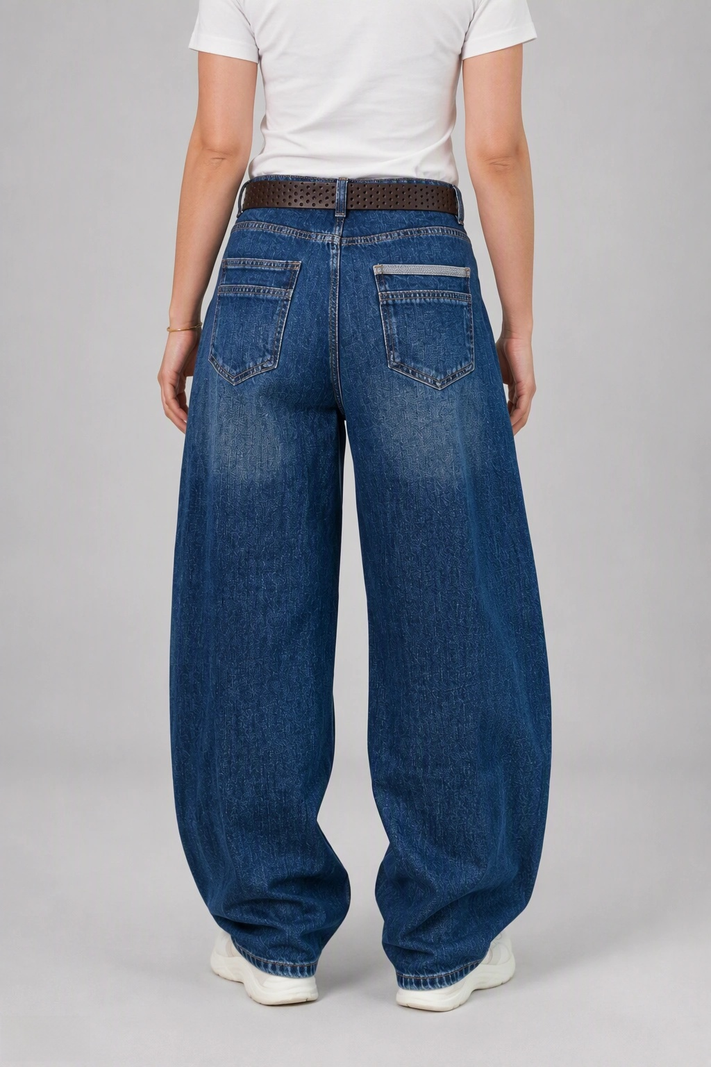 Back view of QAYQEY sun-faded mid-blue curved-leg jeans, waist-down crop on model