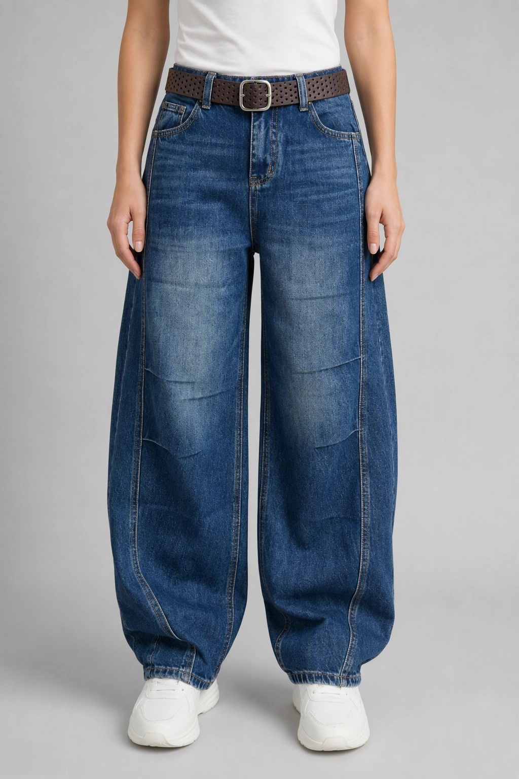 Front view of QAYQEY sun-faded mid-blue curved-leg jeans, waist-down crop on model