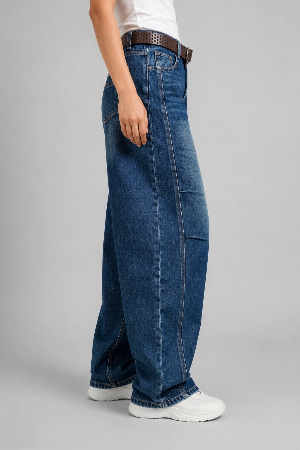 Side view of QAYQEY sun-faded mid-blue curved-leg jeans, showing the curved outseam