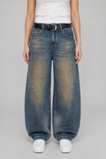 Front view of QAYQEY blue vintage-wash studded curved-leg jeans, waist-down crop on model