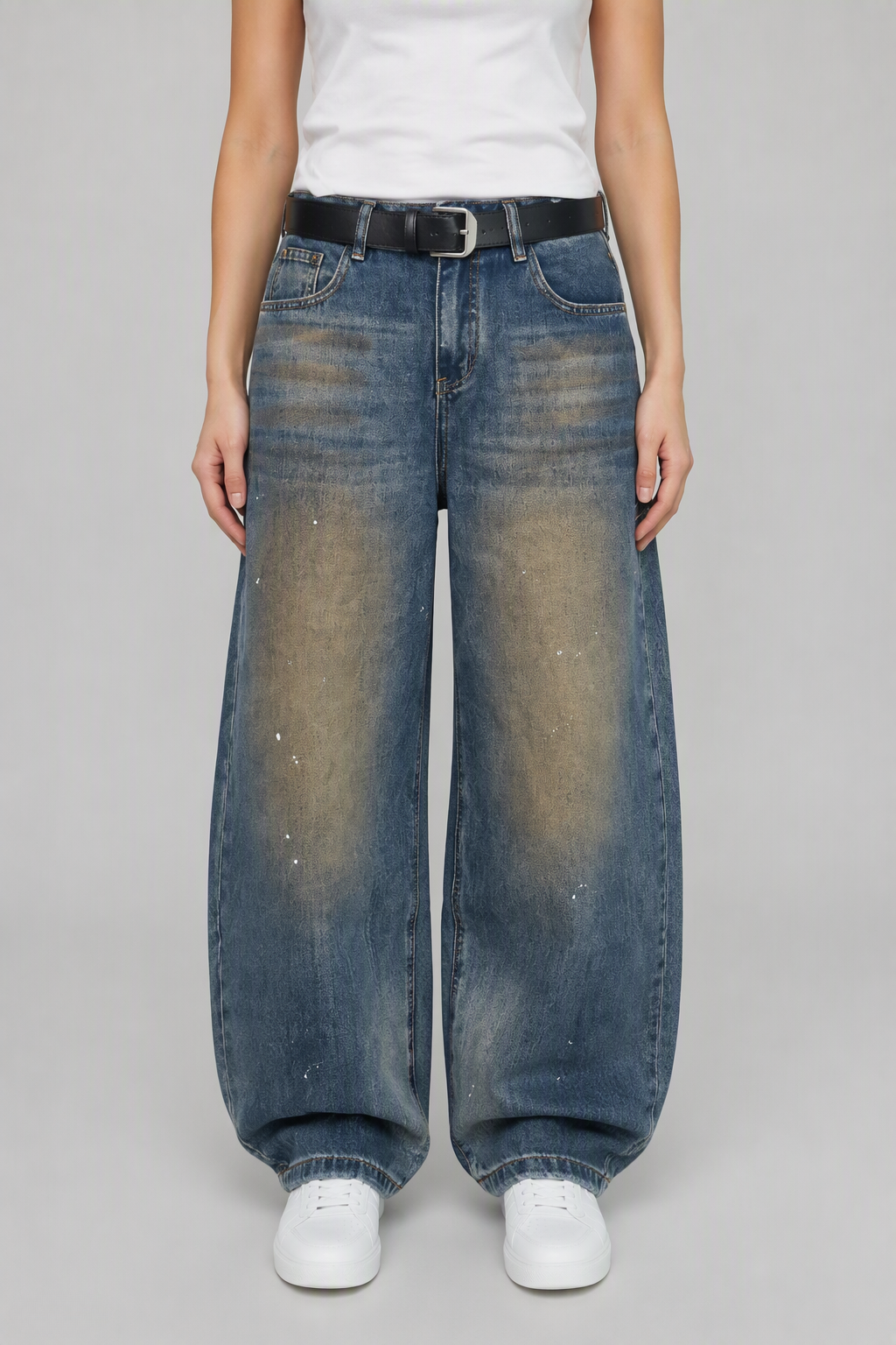Front view of QAYQEY blue vintage-wash studded curved-leg jeans, waist-down crop on model