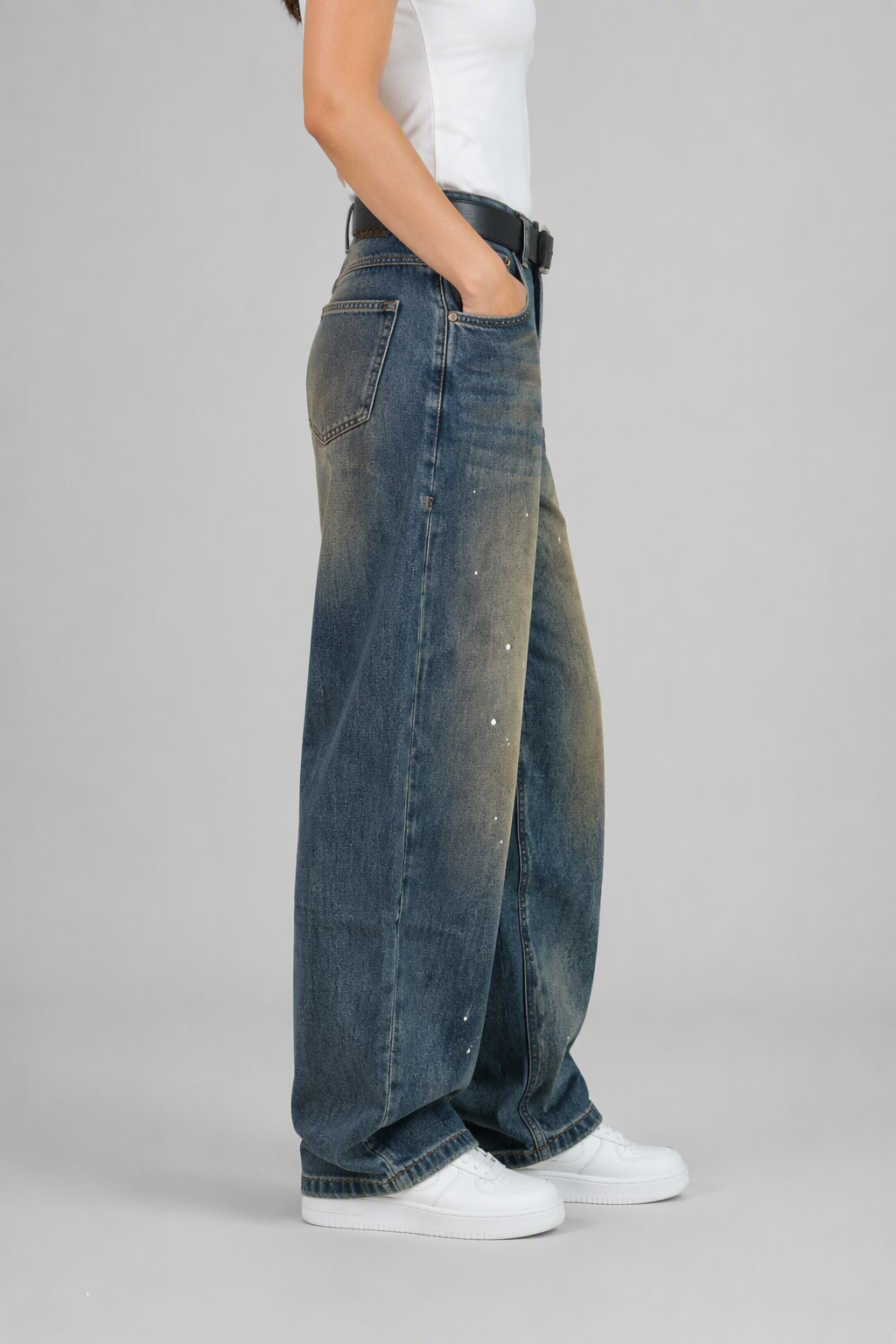 Side view of QAYQEY blue vintage-wash studded curved-leg jeans, showing the curved outseam
