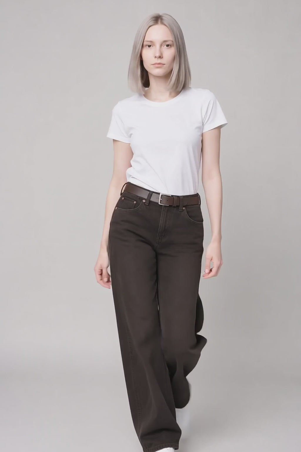 Model wearing Copper-Detail Straight-Leg Jeans in Dark Brown, walking and turning to show the straight-leg fit and copper hardware details.