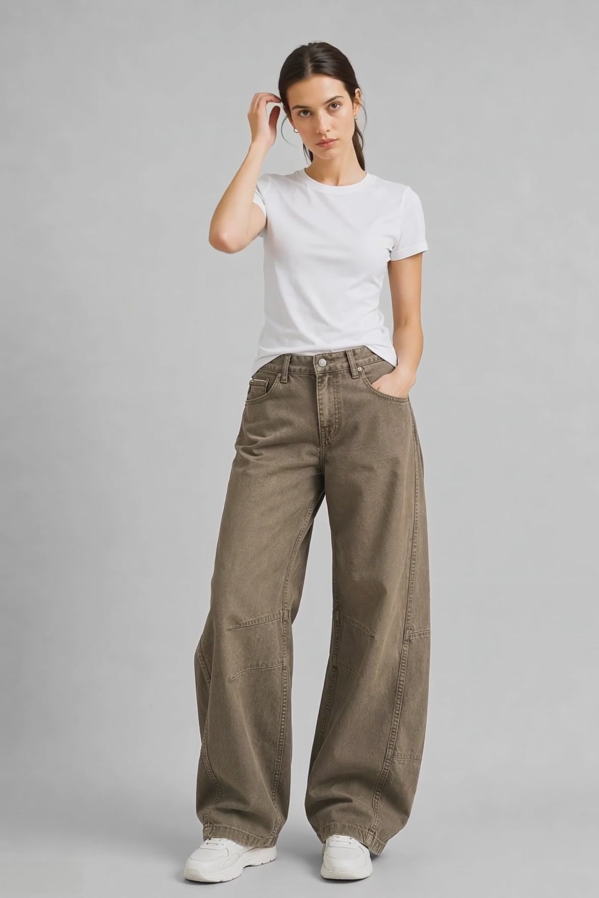 Model wearing Curved-Leg Jeans in Olive Green, walking and turning to show the curved-leg fit and olive green denim finish.