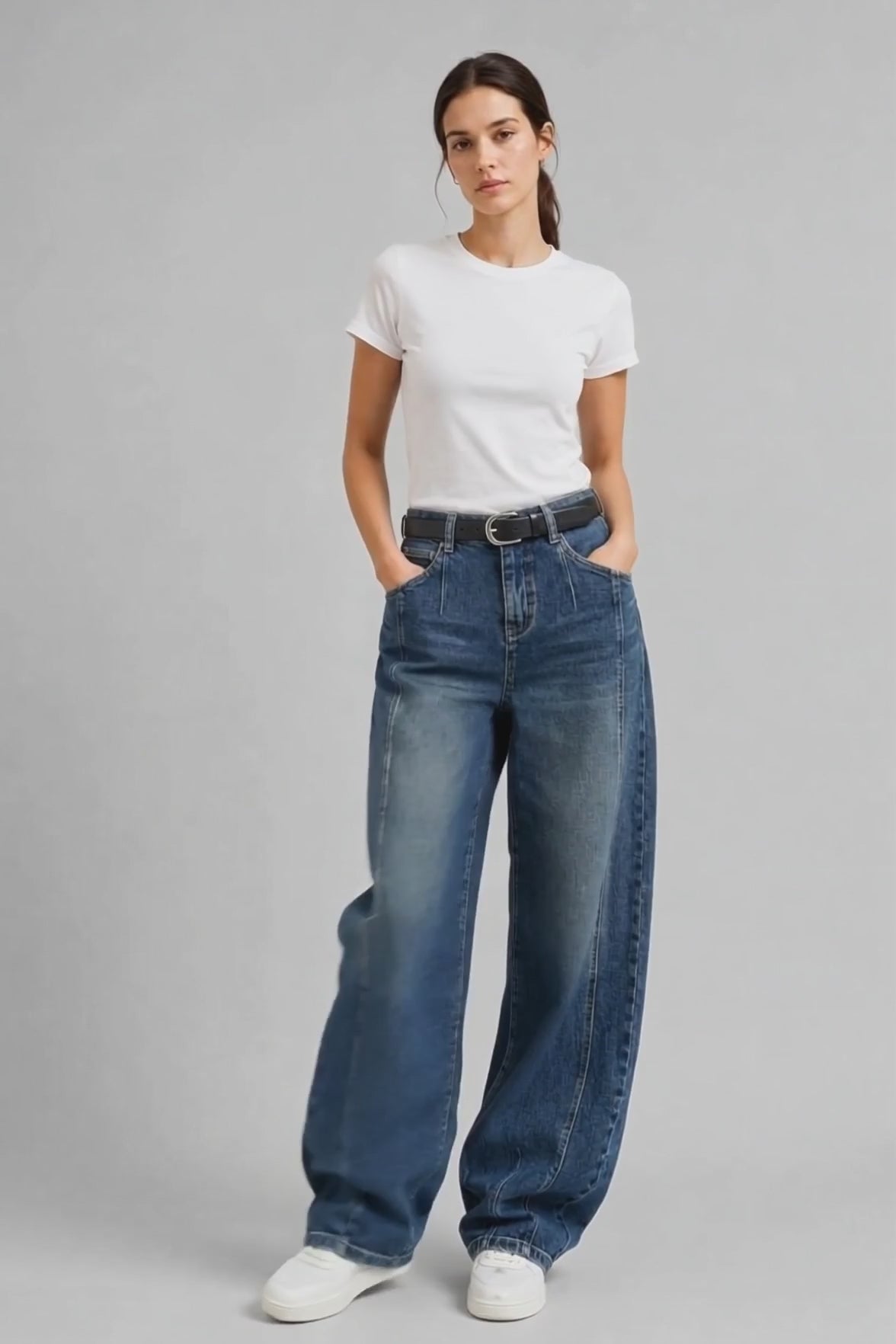 Model wearing Curved-Leg Jeans in Vintage Blue, walking and turning to show the curved-leg fit and vintage blue wash.